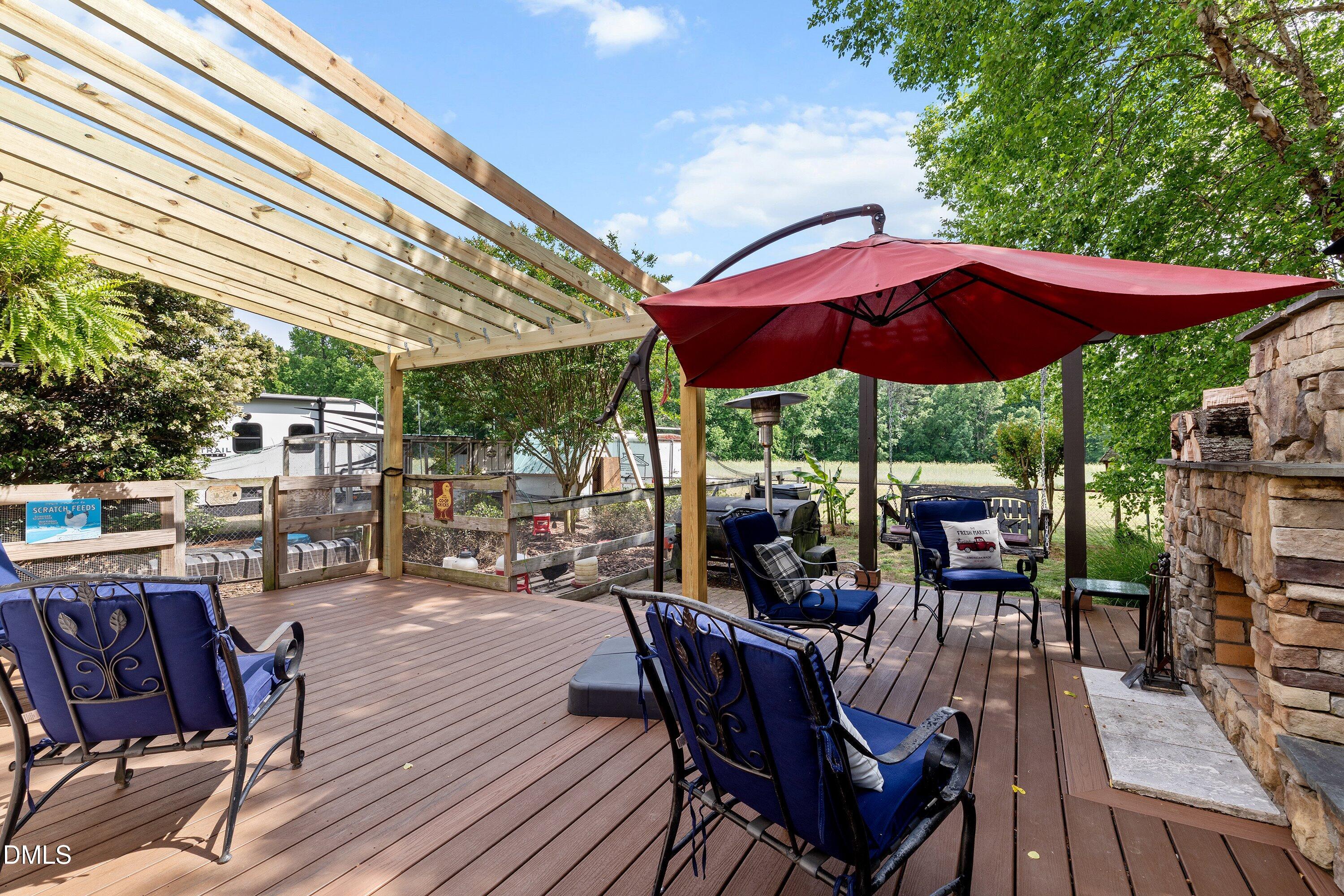 6612 Fowler Road Zebulon, NC 27597 - Photo 38 of 42 a view of a roof deck with table and chairs under an umbrella with a barbeque