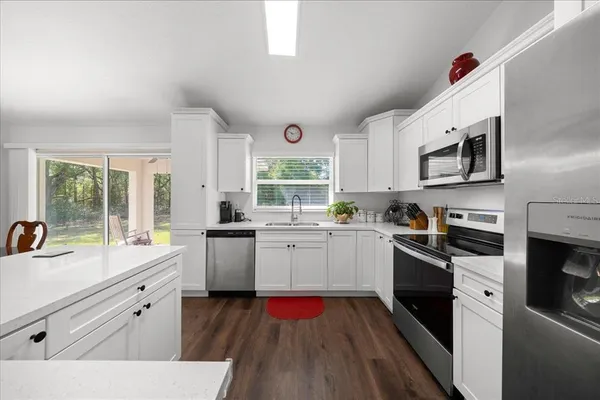 a kitchen with a sink cabinets appliances and a window
