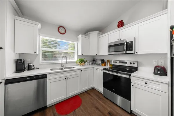 a kitchen with a sink stove and microwave