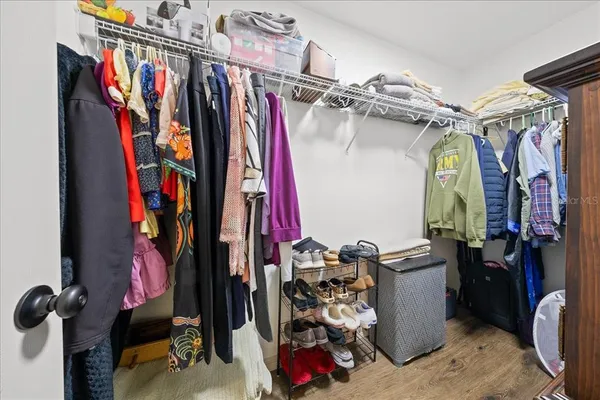 a view of walk in closet with clothes and shoes