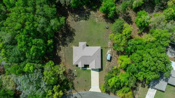 an aerial view of a house with a yard and garden