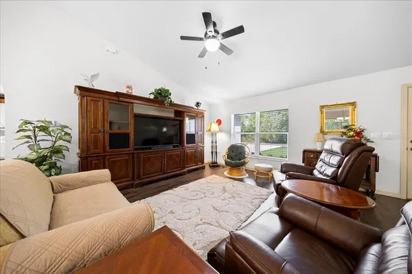 a living room with furniture a flat screen tv and a window