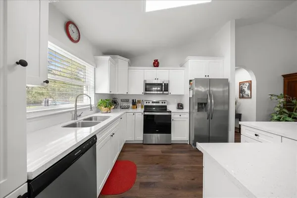 a kitchen with granite countertop a refrigerator and a sink