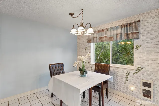 a view of a dining room with furniture a chandelier and large windows