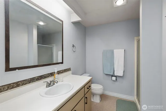 a bathroom with a toilet sink a mirror and vanity