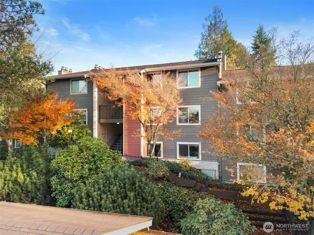 a view of a brick house with a large windows and flower plants