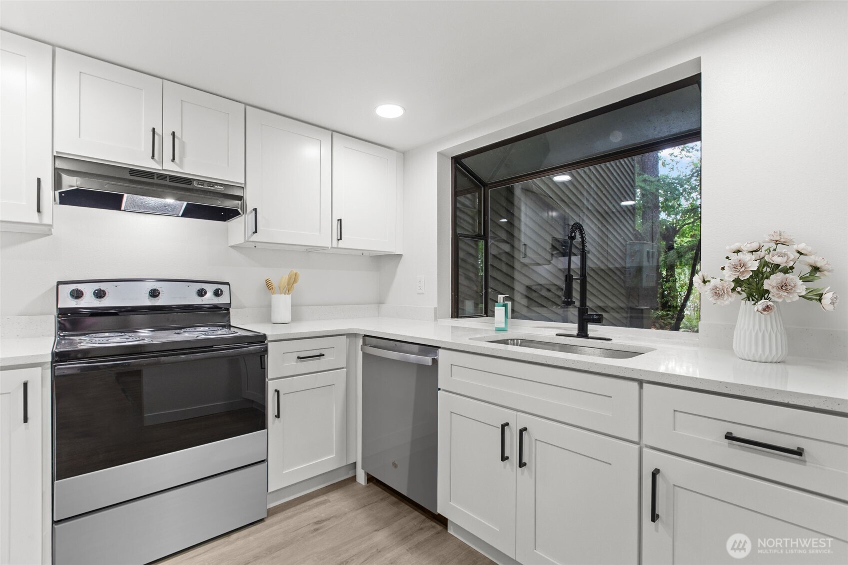 138 Southwest 116th Street, Unit G15 Seattle, WA 98146 - Photo 7 of 21 a kitchen with white cabinets stainless steel appliances and sink