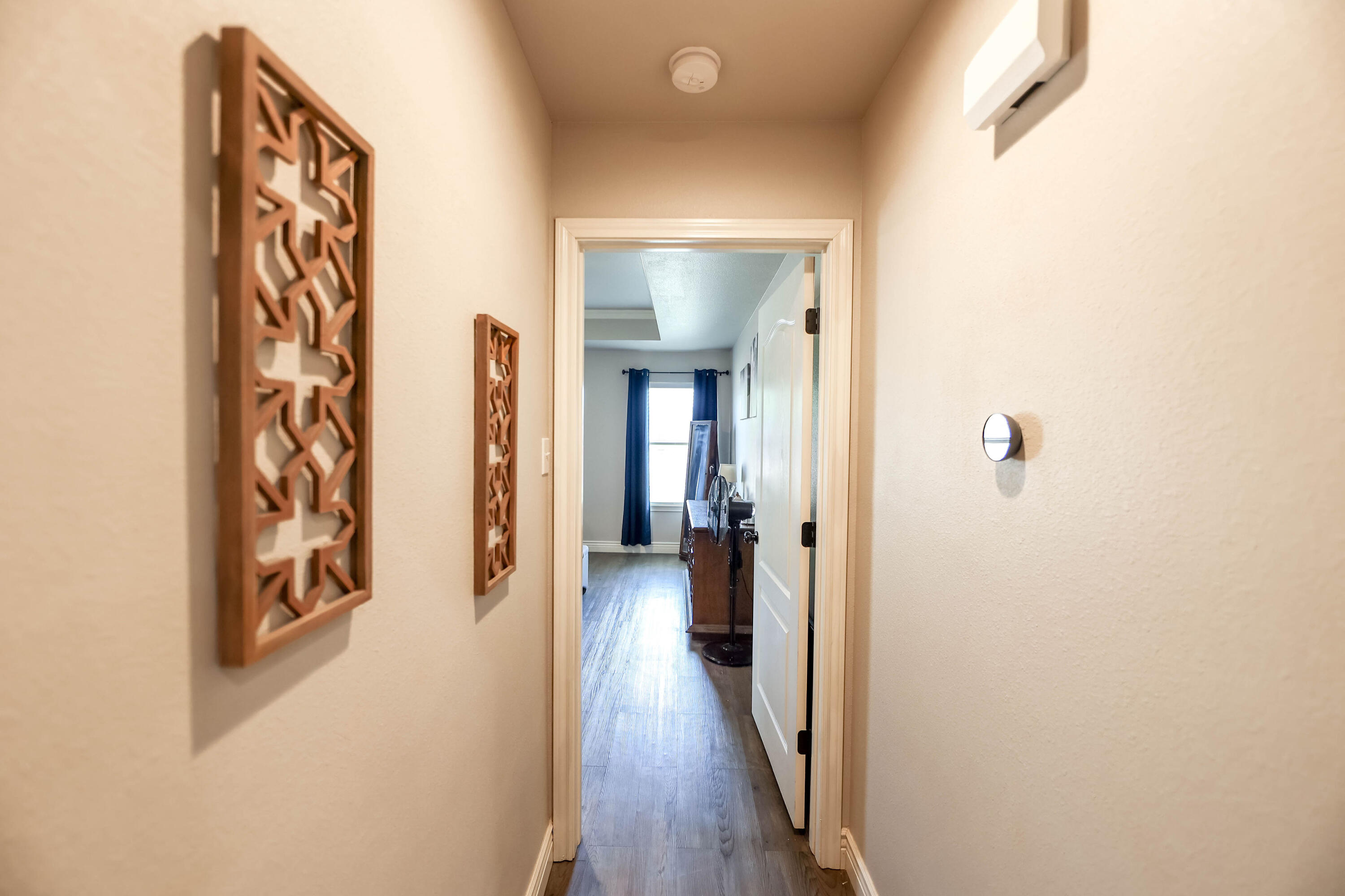 6008 103rd Street Lubbock, TX 79424 - Photo 11 of 29 a view of a hallway with wooden floor and a living room