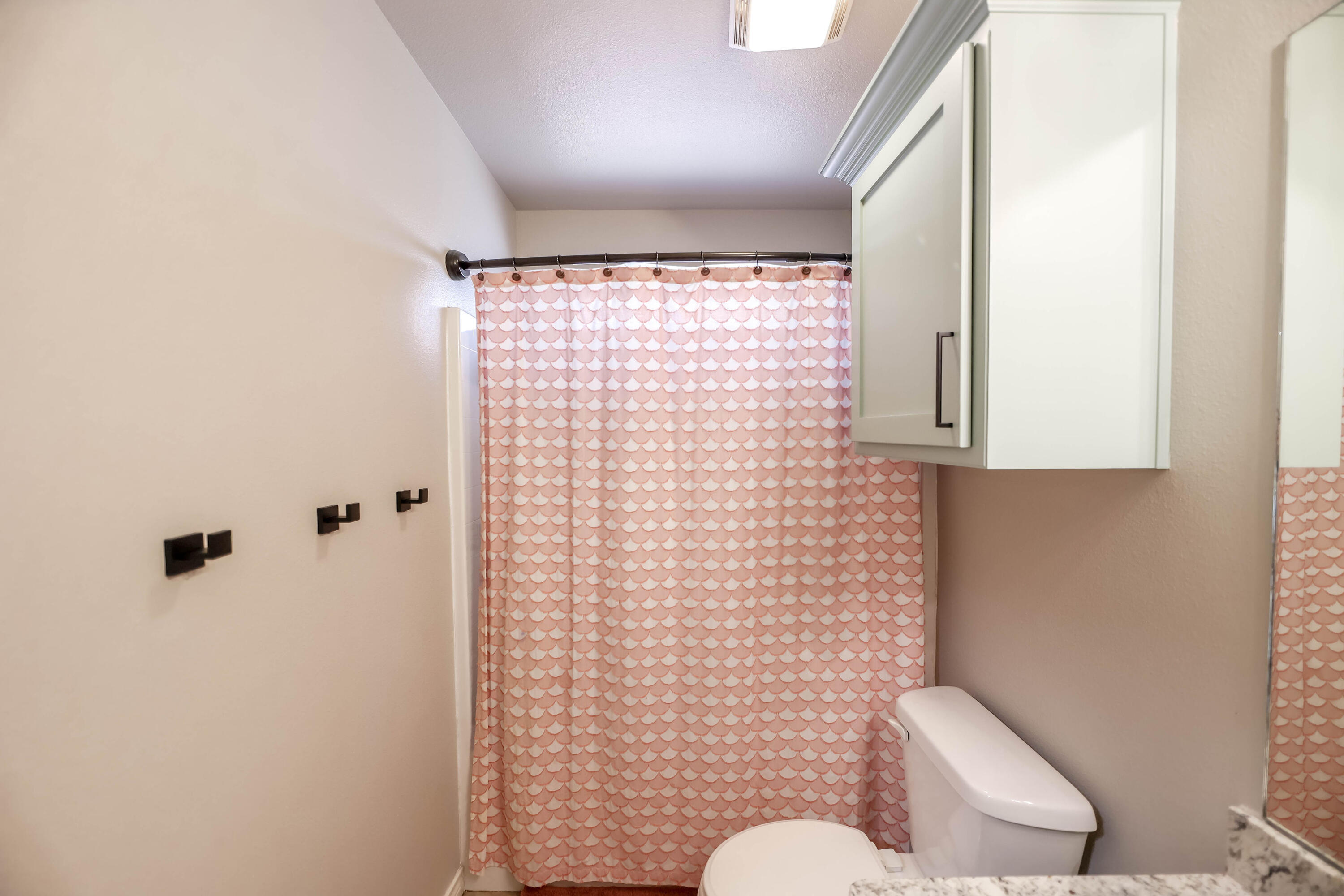 6008 103rd Street Lubbock, TX 79424 - Photo 22 of 29 a bathroom with a toilet sink and shower curtain
