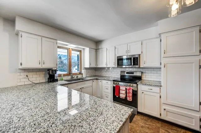 a bathroom with a granite countertop sink and a shower