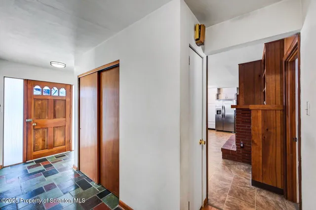 a view of an empty room with furniture and a kitchen