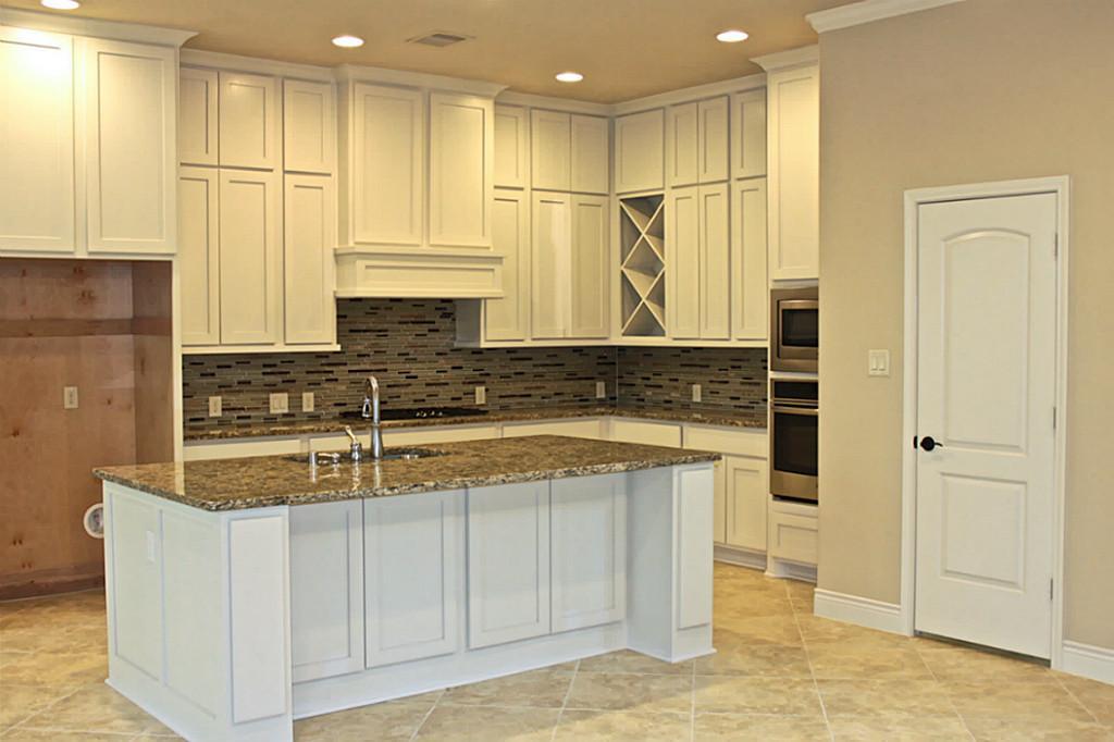 a kitchen with stainless steel appliances granite countertop a sink and a refrigerator