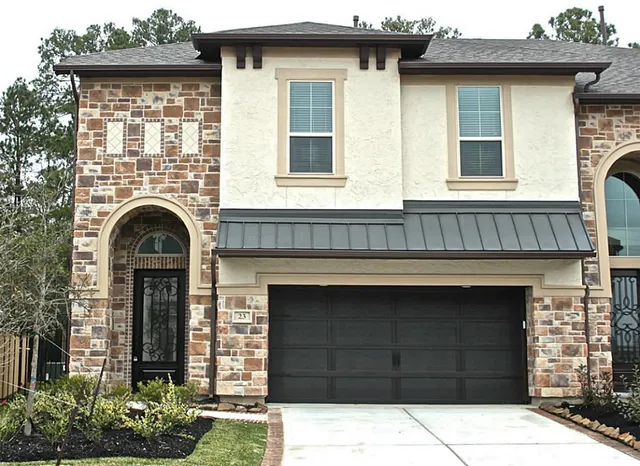 a front view of a house with a garden and garage