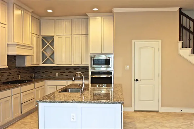 a kitchen with stainless steel appliances granite countertop a sink and a stove