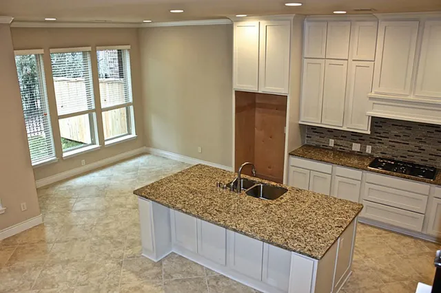 a kitchen with granite countertop cabinets and window