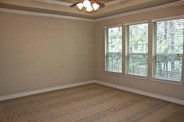 a view of an empty room with a window and hardwood floor