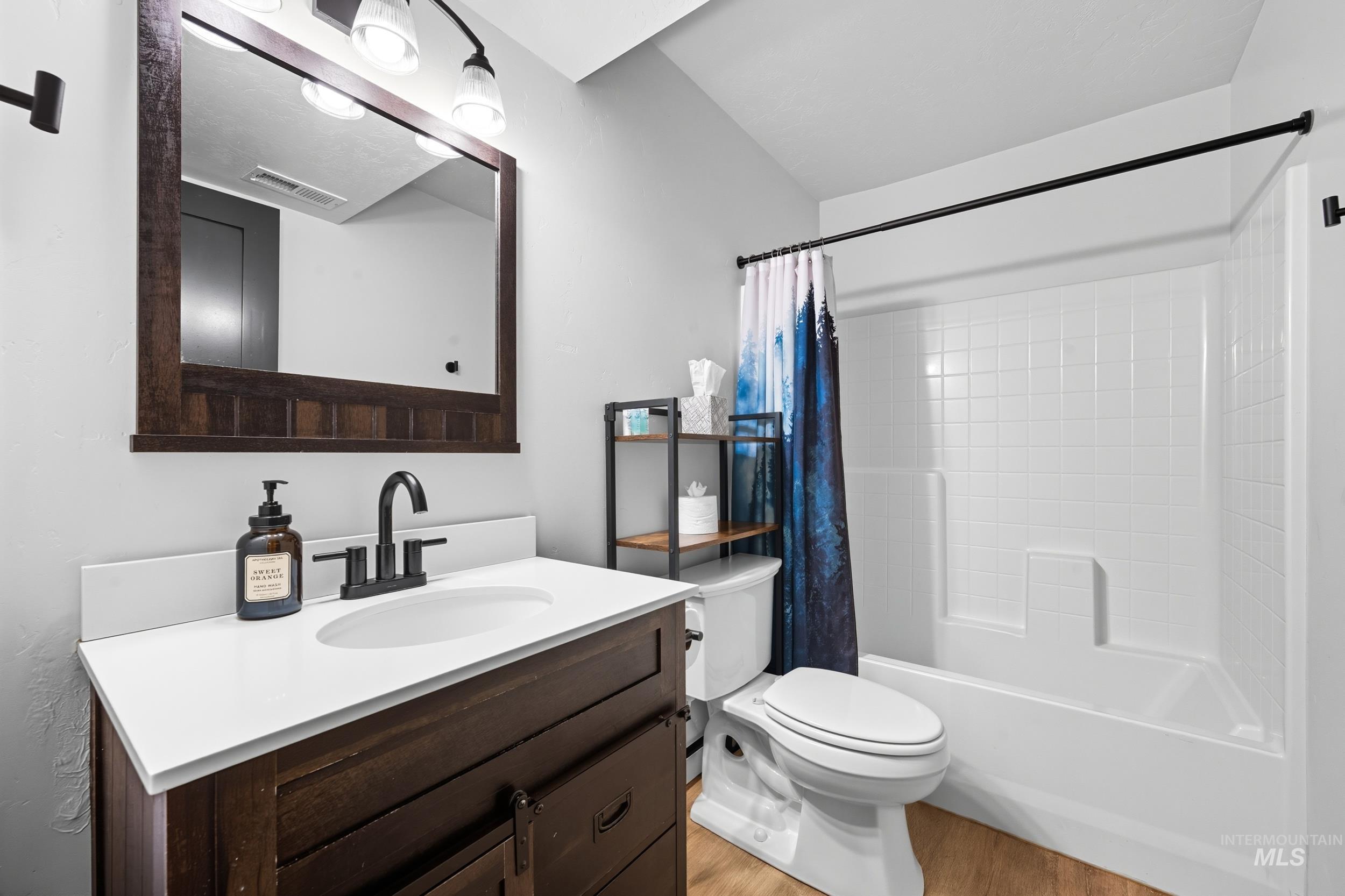 24 Rainbow Ridge Road Garden Valley, ID 83622 - Photo 18 of 32 Bathroom with shower / bathtub combination with curtain, light wood-style flooring, and vanity