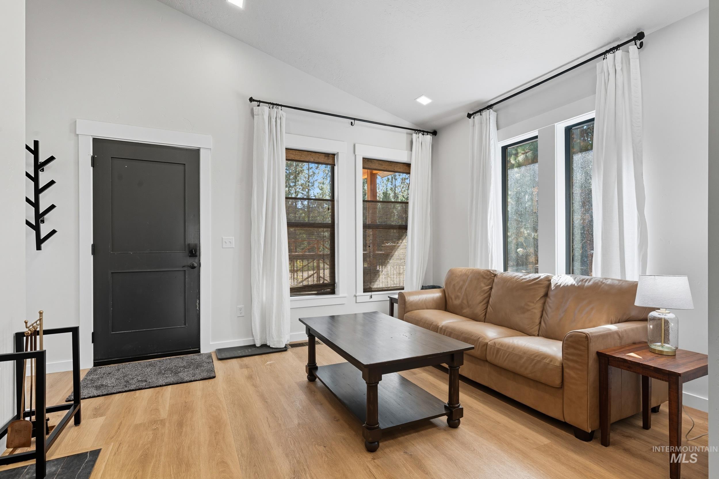 24 Rainbow Ridge Road Garden Valley, ID 83622 - Photo 3 of 32 Living room featuring vaulted ceiling, healthy amount of natural light, and light wood-type flooring