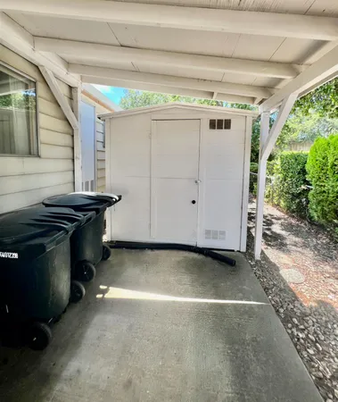 a backyard of a house with wooden fence and large trees