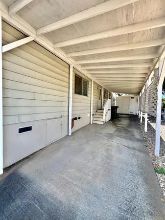 a view of a backyard with a large tree and wooden fence
