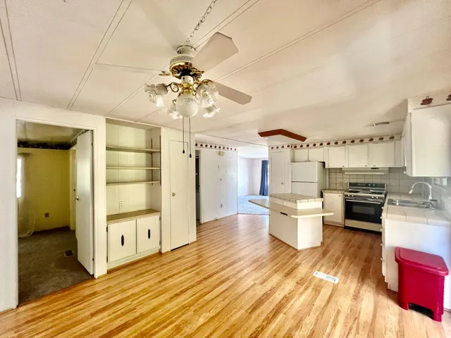 a open kitchen with stainless steel appliances a dining table chairs stove and kitchen view