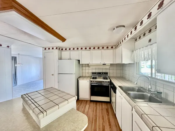 a kitchen with stainless steel appliances granite countertop a sink stove and refrigerator