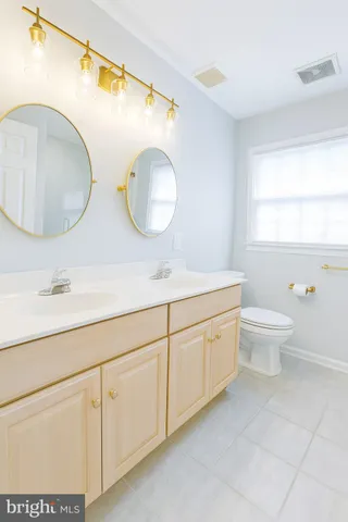 an empty room with windows and chandelier fan