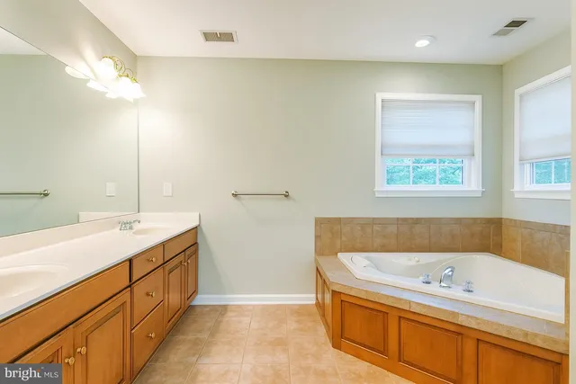 an empty room with windows and chandelier fan