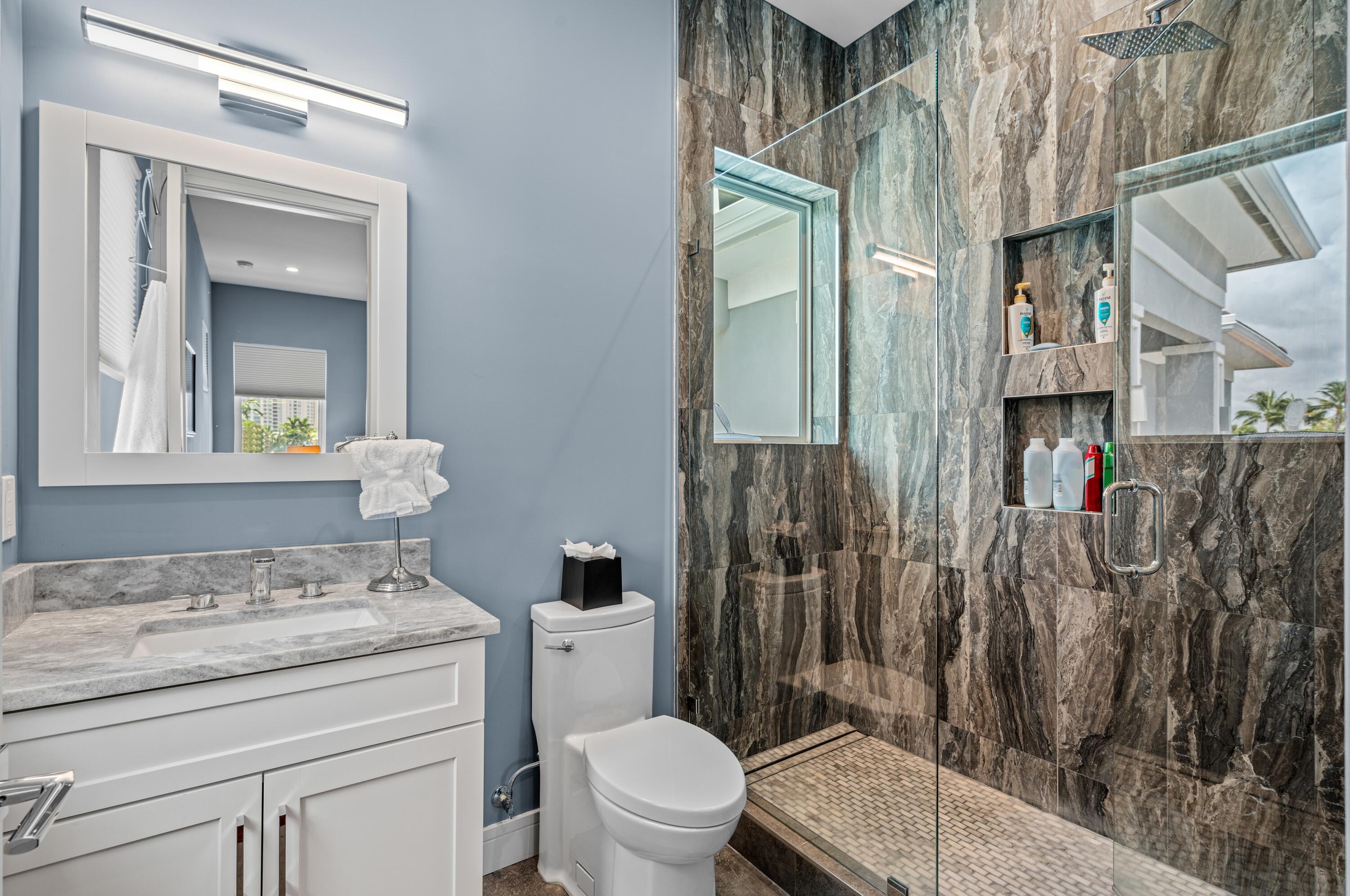 807 Dover Street Boca Raton, FL 33487 - Photo 19 of 47 a bathroom with a granite countertop sink a toilet a mirror and shower