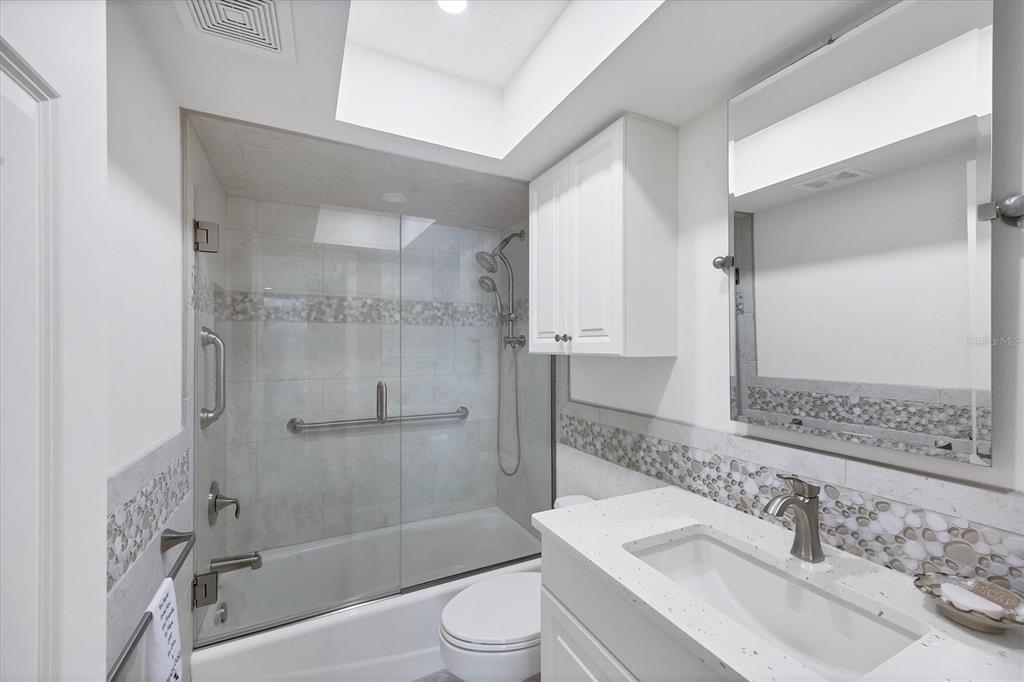 2810 North Beach Road, Unit D205 Englewood, FL 34223 - Photo 34 of 48 a bathroom with a bathtub shower sink vanity and toilet