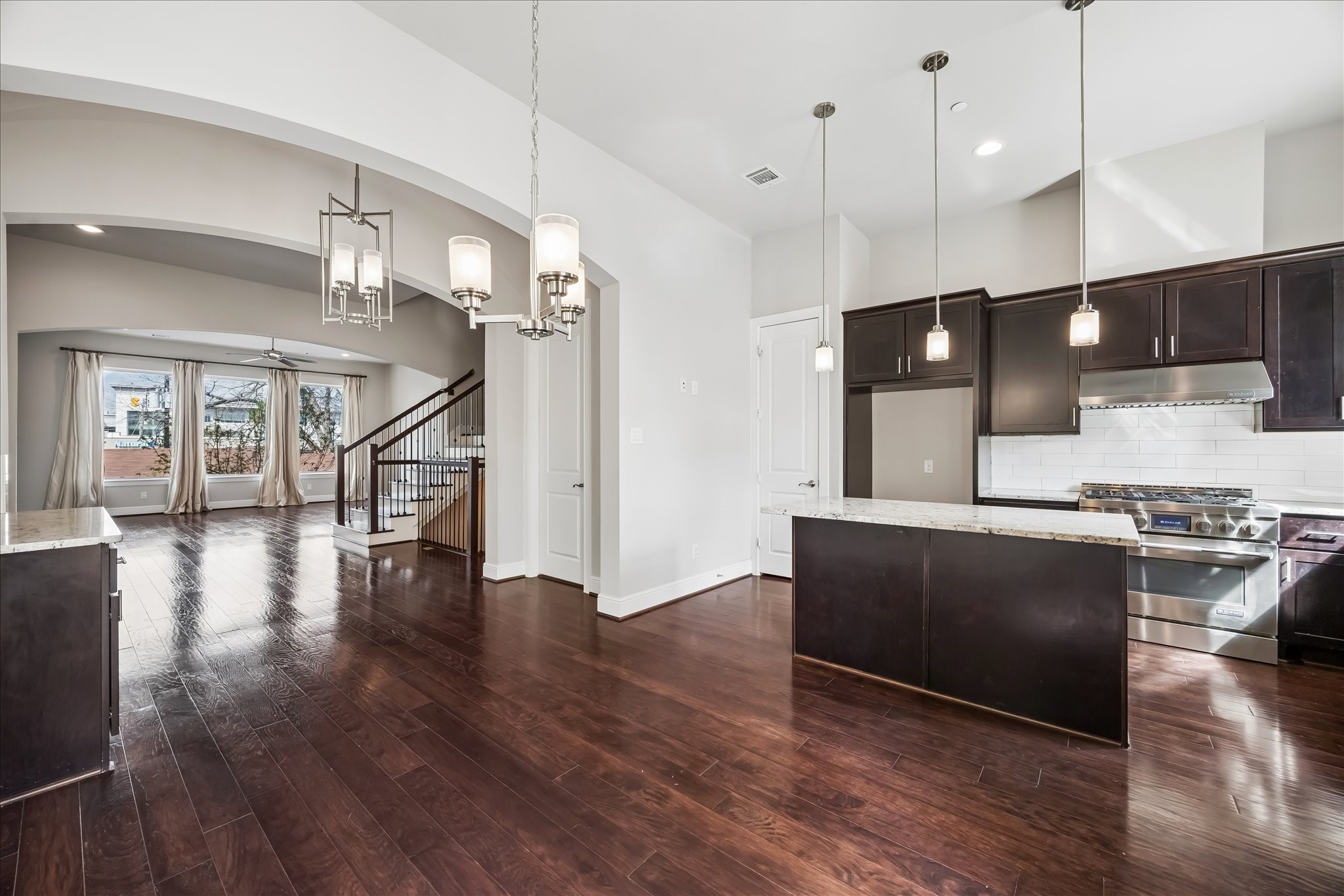 4016 Barnes Street Houston, TX 77007 - Photo 13 of 37 a kitchen with stainless steel appliances granite countertop a stove a refrigerator a sink and a microwave with wooden floor