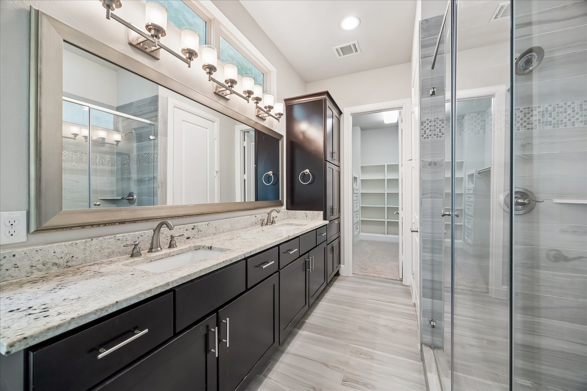 4016 Barnes Street Houston, TX 77007 - Photo 26 of 37 a bathroom with a granite countertop sink a large mirror and a shower