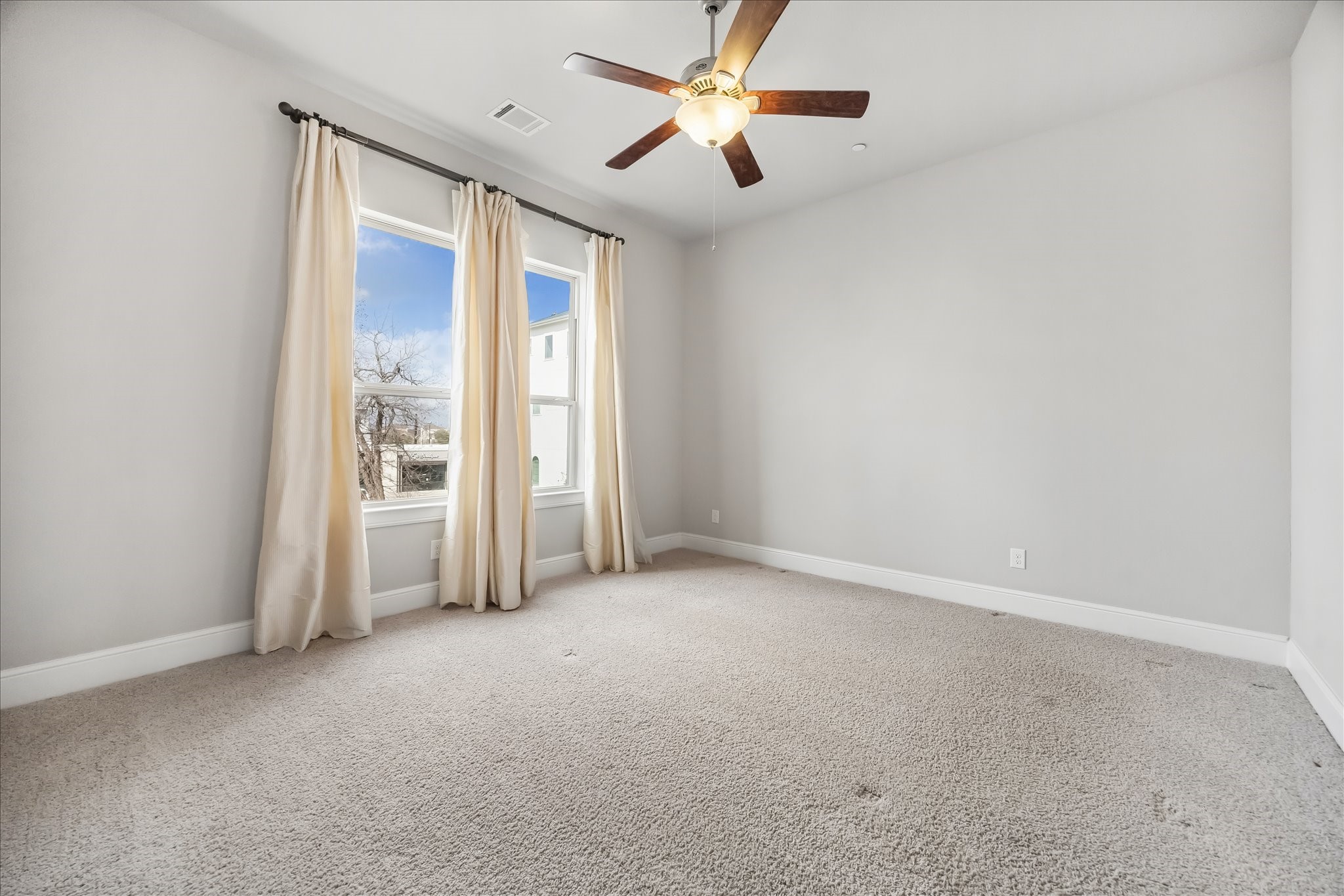 4016 Barnes Street Houston, TX 77007 - Photo 28 of 37 an empty room with chandelier fan and windows