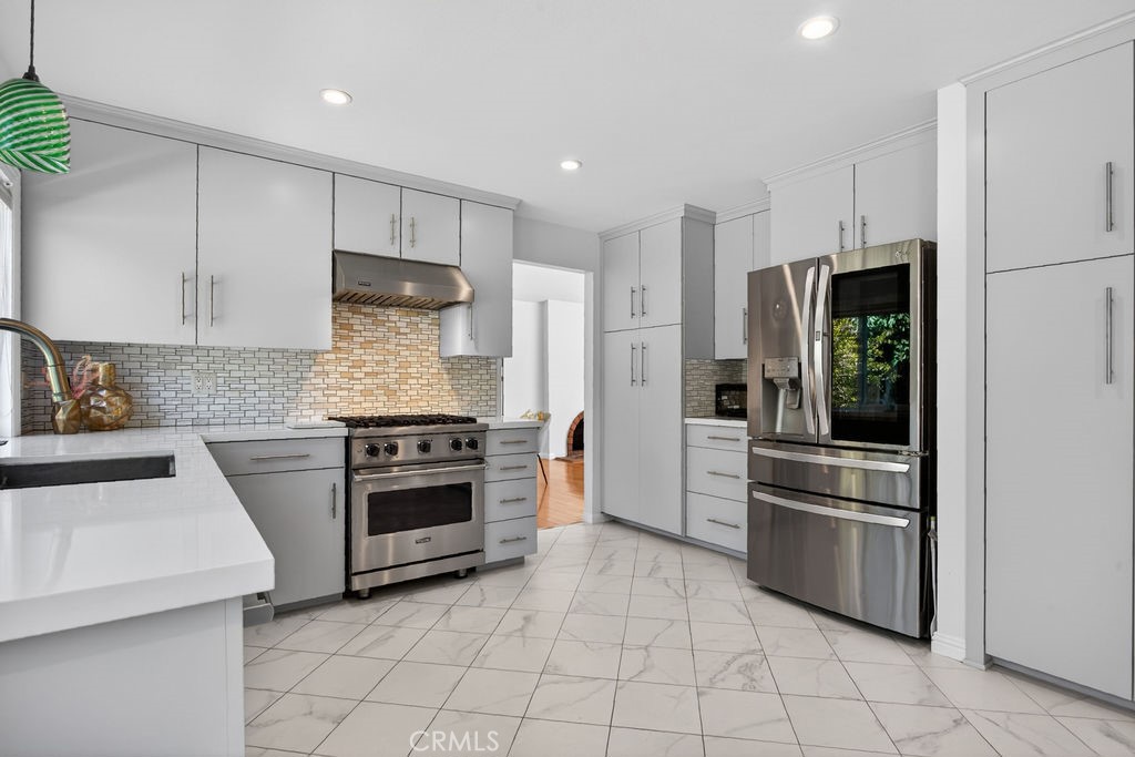 1663 North Yurok Street Orange, CA 92867 - Photo 15 of 31 a kitchen with white cabinets and stainless steel appliances