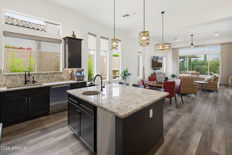 a bathroom with a granite countertop sink a mirror and shower