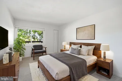 a bedroom with a bed a couch and a flat screen tv