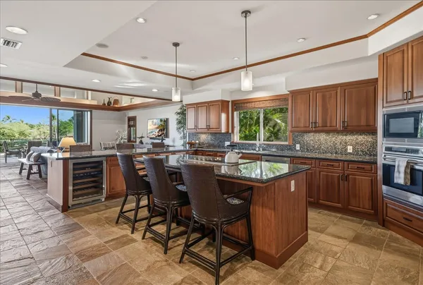 a kitchen with stainless steel appliances granite countertop a sink a stove a refrigerator cabinets and dining table