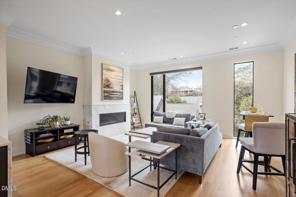 a living room with furniture a flat screen tv and large windows