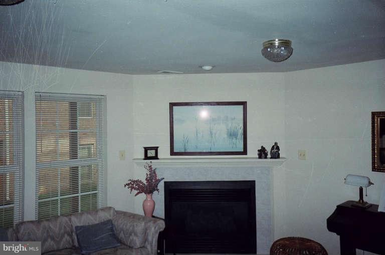 8 Chippewa Court Silver Spring, MD 20906 - Photo 14 of 30 a living room with furniture a flat screen tv and a fireplace