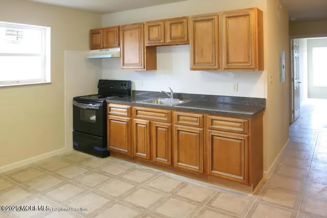 a kitchen with stainless steel appliances granite countertop a stove a sink and a refrigerator