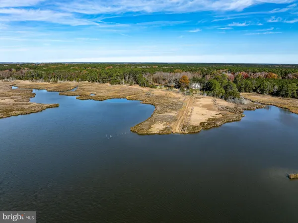 a view of a brick house with a small yard and wooden fence