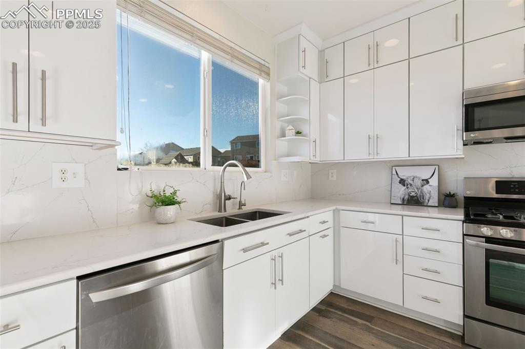 9202 Ballybunion Road Peyton, CO 80831 - Photo 12 of 36 a kitchen with stainless steel appliances white cabinets and a sink