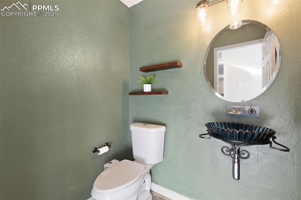 9202 Ballybunion Road Peyton, CO 80831 - Photo 22 of 36 a bathroom with a toilet a sink and mirror