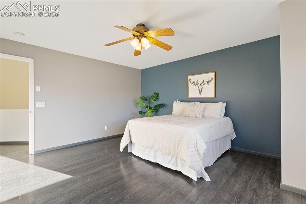 9202 Ballybunion Road Peyton, CO 80831 - Photo 25 of 36 a bedroom with a bed and a chandelier