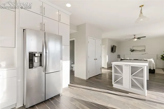 a kitchen with kitchen island white cabinets and stainless steel appliances