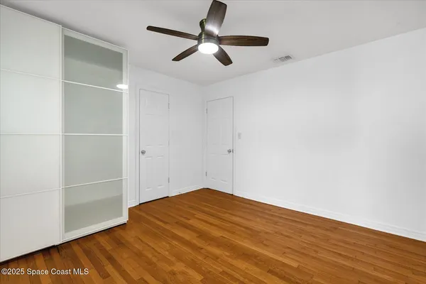 a view of empty room with wooden floor