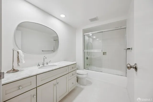 a bathroom with a double vanity sink toilet mirror and shower