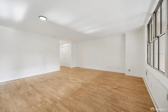 a view of empty room with wooden floor