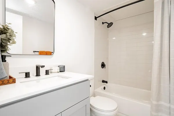 a bathroom with a granite countertop sink toilet and shower