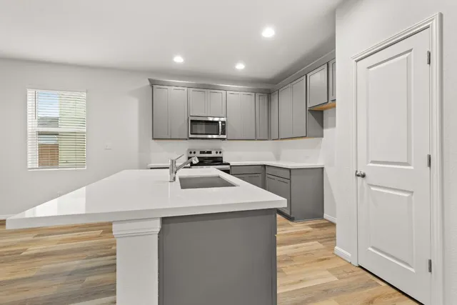a kitchen with kitchen island white cabinets appliances and a window